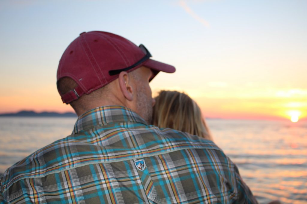 A man with a red hat and sunglasses looking at the sunset in Croatia.