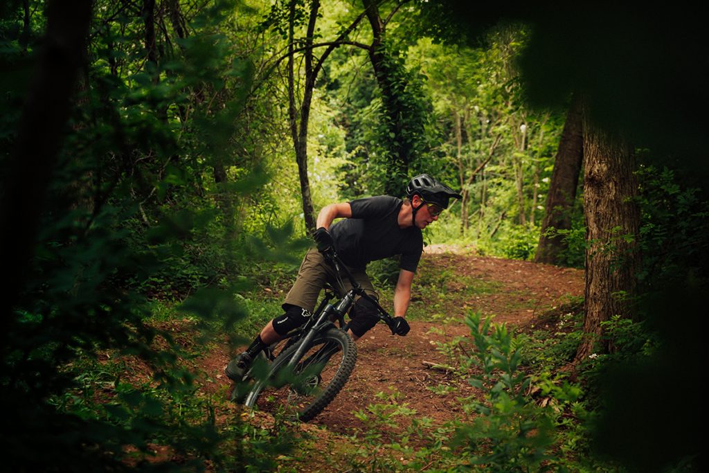 man riding bicycle in forest during daytime 