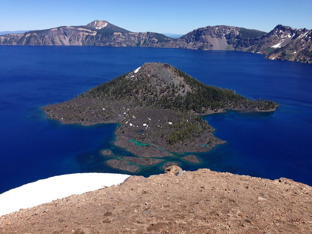 rock formation rising from the blue lake