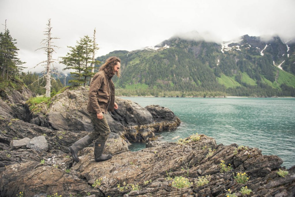 Lessons from Dad - A man walking up a gray rock next to a lake