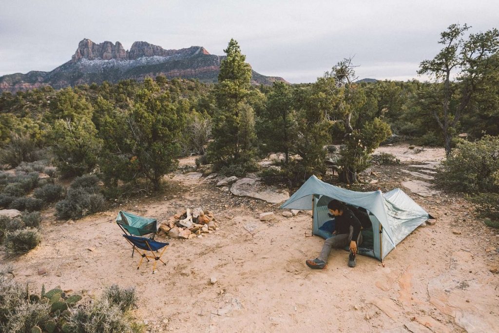 man sitting in tent on the ground