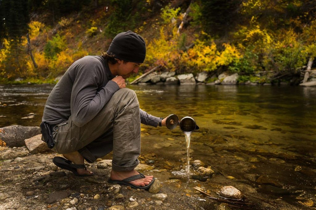 man holding dish next to water