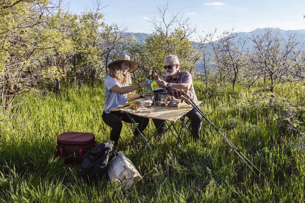 man and woman holding bottles outdoors during daytime 