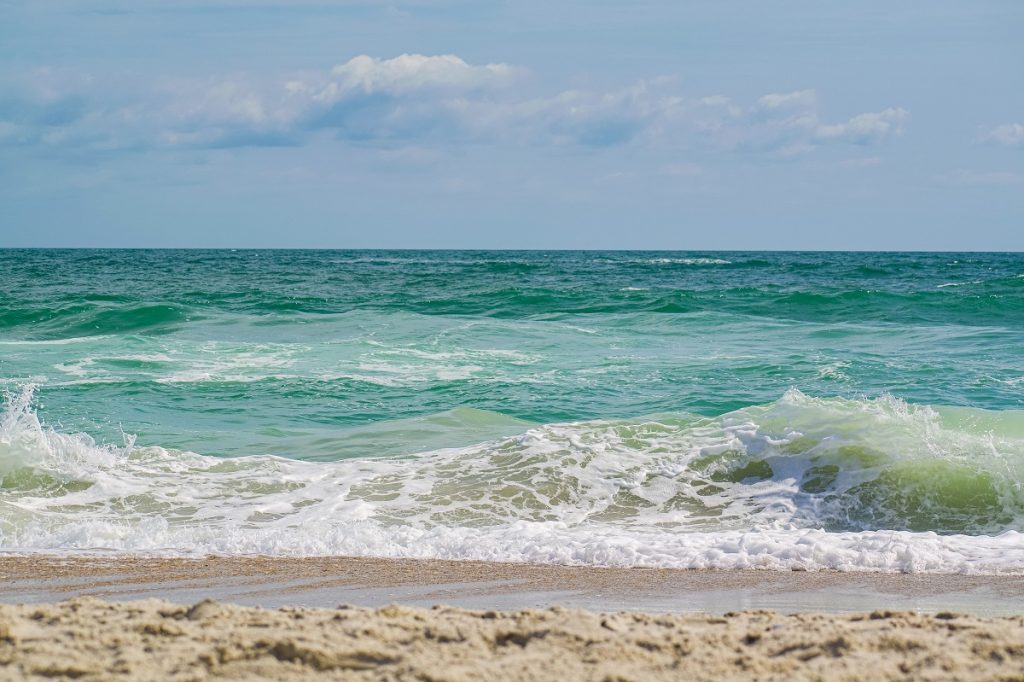 sea waves crashing on shore during daytime