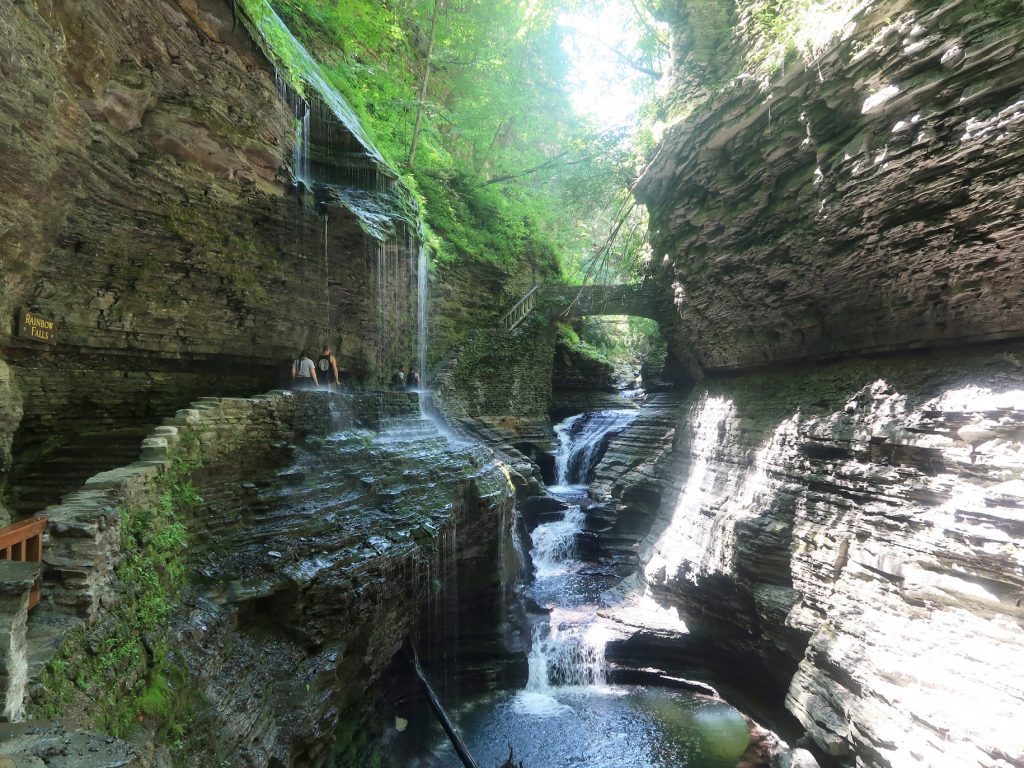 tall rock formations with waterfall in the middle and trails on the sides