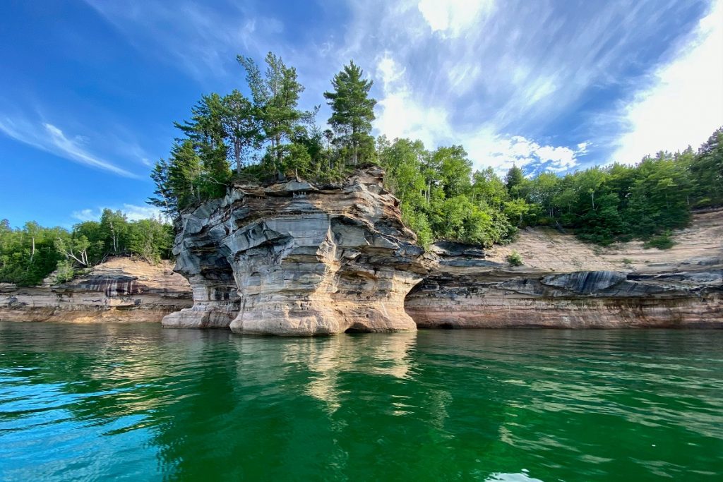 green trees on a cliff with green water in front