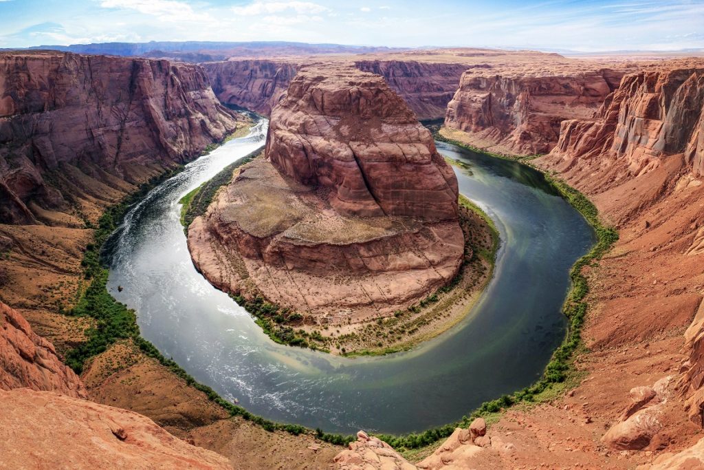 rock formation surrounded by water and cliffs