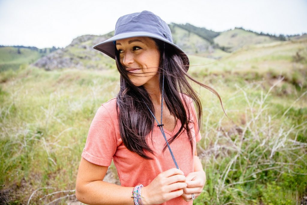 woman in KÜHL Inara shirt and KÜHL Sun Blade Hat in the outdoors